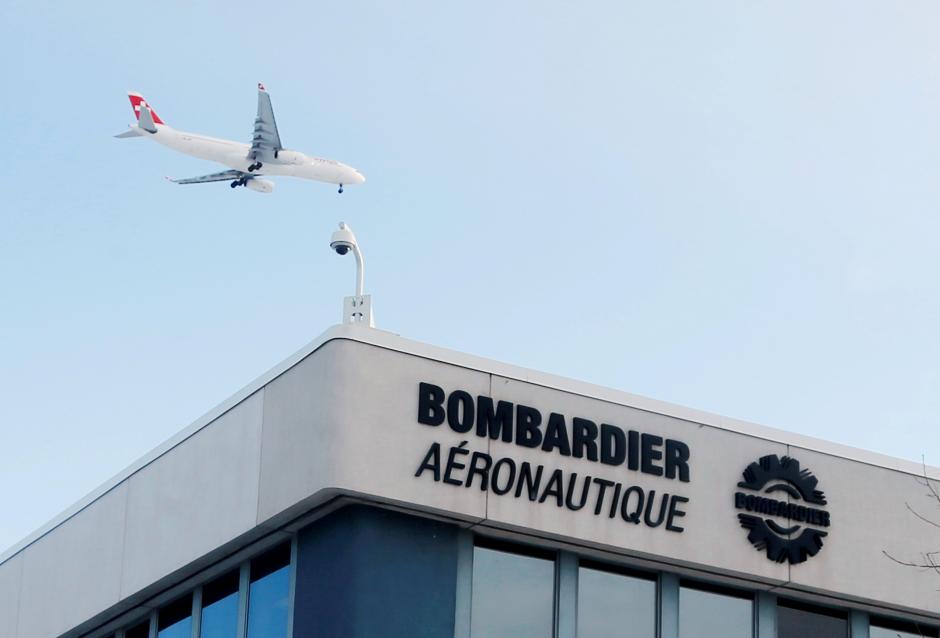 FILE PHOTO – A plane flies over a Bombardier plant in Montreal