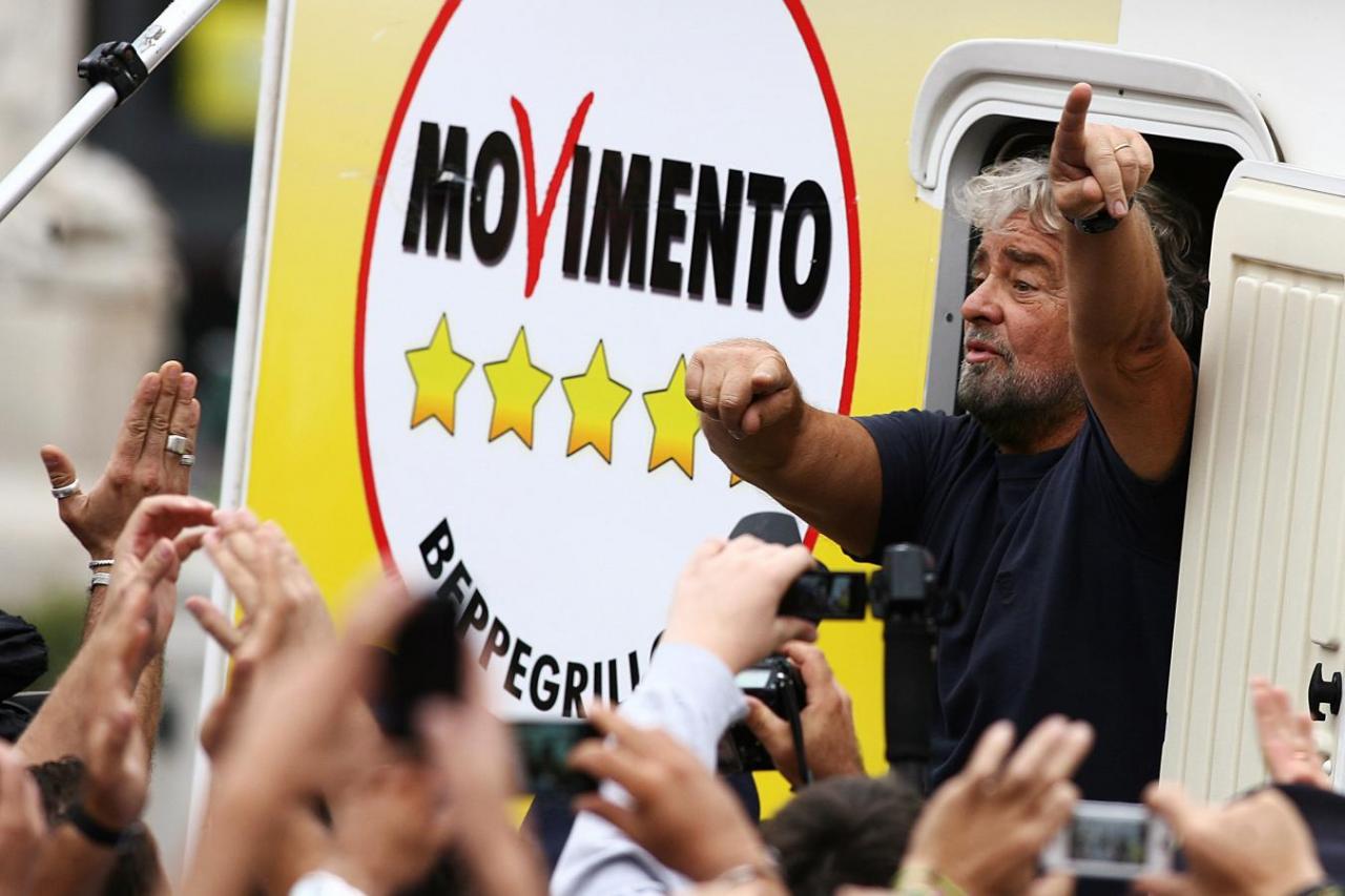 Five-Star Movement activist and comedian Beppe Grillo gestures as he arrives for a rally in the Sicily town of Termini Imerese