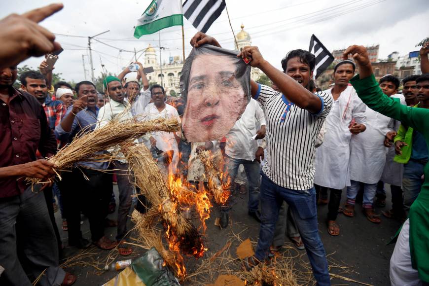 Protestors burn an image of Myanmar’s leader Aung San Suu Kyi
