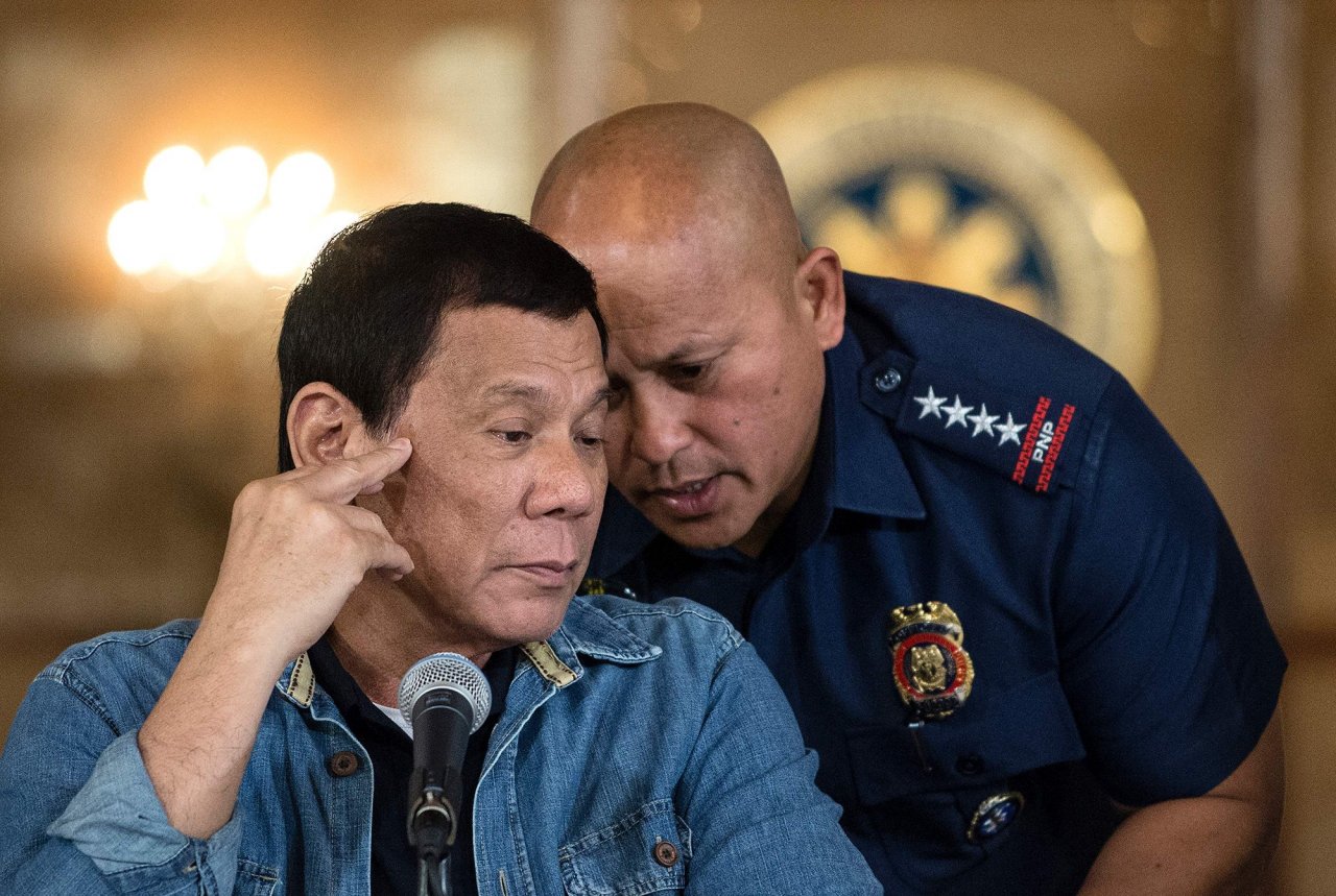 Philippine President Rodrigo Duterte (L) talks to Philippine National Police (PNP) Director General Ronald Dela Rosa (R) during a press conference at the Malacanang palace in Manila on January 30, 2017.