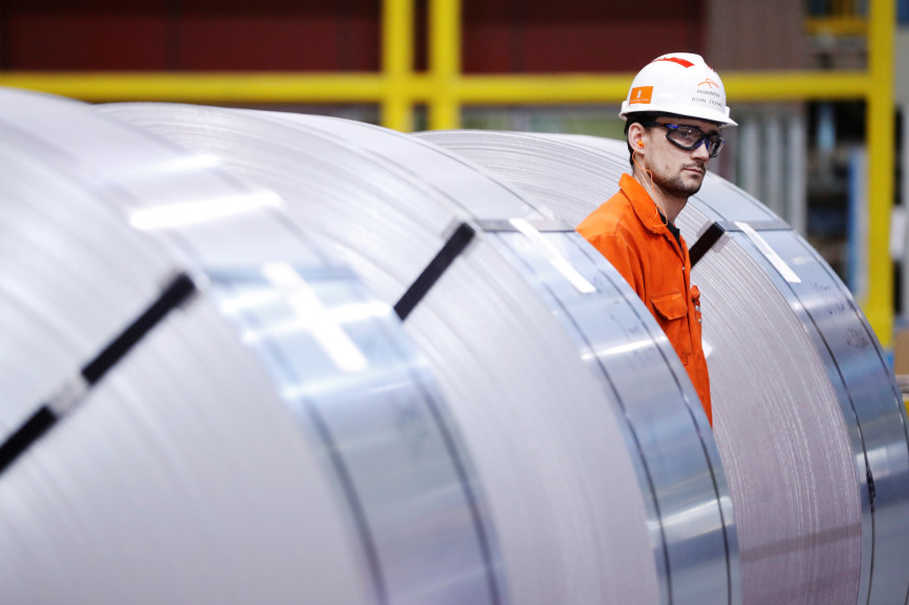 A worker looks at rolls of steel at the ArcelorMittal Dofasco steel plant in Hamilton