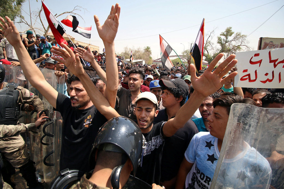People shout slogans during a protest near the main provincial government building in Basra