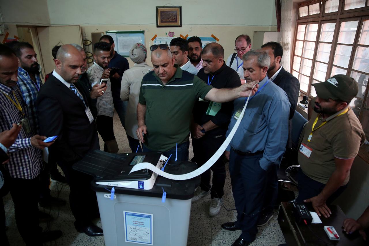 Iraq’s Independent High Electoral Commission employee closes a ballot box at a polling station during the parliamentary election in Baghdad