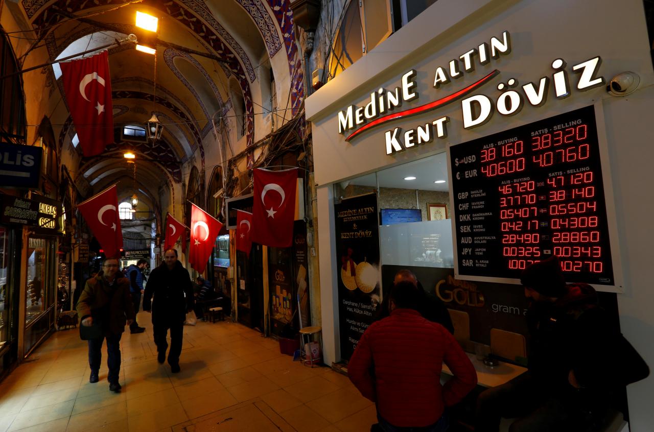 Merchants chat in front of a currency exchange office at the historical Grand Bazaar, known as the Covered Bazaar, in Istanbul