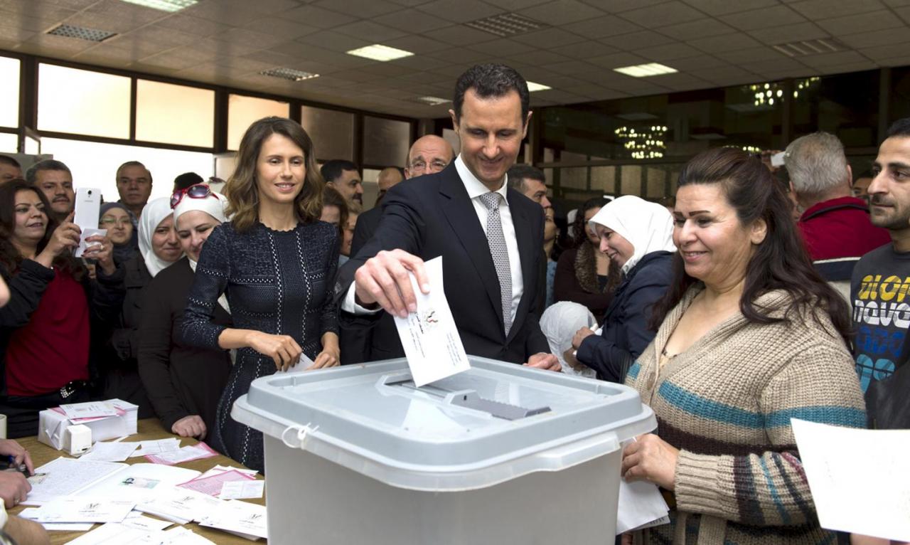 Syria’s President Bashar al-Assad casts his vote next to his wife Asma inside a polling station during the parliamentary elections in Damascus