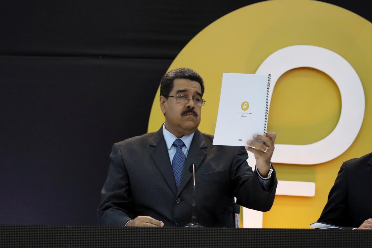 Venezuela’s President Nicolas Maduro reads a document during the event launching the new Venezuelan cryptocurrency “Petro” in Caracas