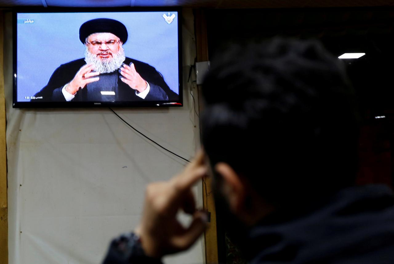 FILE PHOTO: A man watches Lebanon’s Hezbollah leader Sayyed Hassan Nasrallah as he speaks on television in Beirut