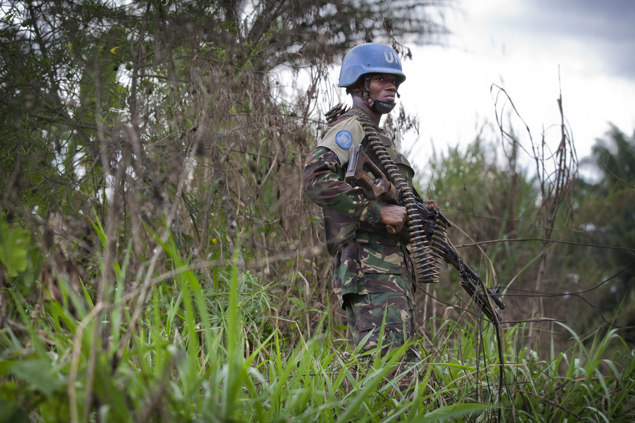 A member of FIB stands in the bush near the front line in the Beni region where the UN is backing the FARDC in an operation against ADF militia, the 13th of March 2014. / Allied Democratic Forces